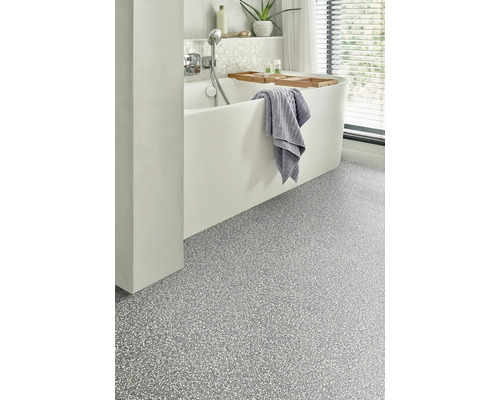 Modernes Badezimmer mit Badewanne, Handtuch und strukturiertem Bodenbelag