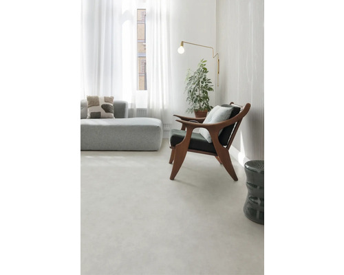 Helles Wohnzimmer mit Sofa, Sessel, Stehlampe und Zimmerpflanze