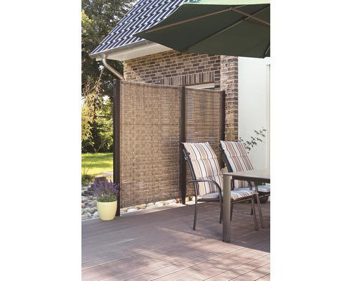 Terrasse mit Sichtschutzwand, Gartentisch und Stühlen unter einem Sonnenschirm