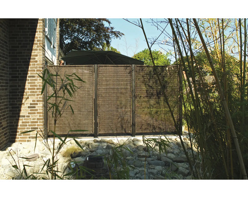 Gartenszene mit Sichtschutzzaun aus natürlichen Materialien und dekorativen Pflanzen