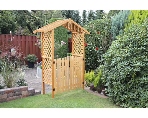 Gartenansicht mit Holztor und Rosenbogen im Garten