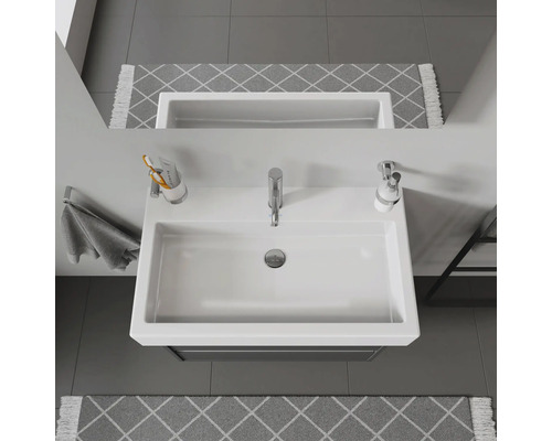 Aufnahme eines weißen Waschbeckens mit Armatur, Seifenspender und Handtuchhalter im Badezimmer