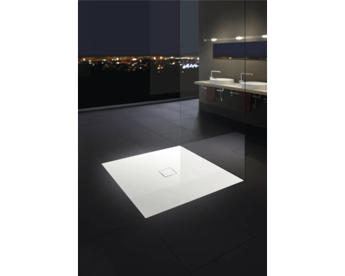 Elegantes Badezimmer mit flacher Duschwanne, Waschtischen und Fensterfront mit Stadtblick bei Nacht.