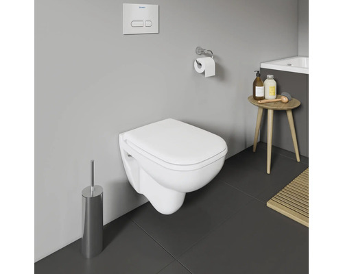 Wandhängendes WC mit Spülkasten und Toilettenbürste in einem Badezimmer