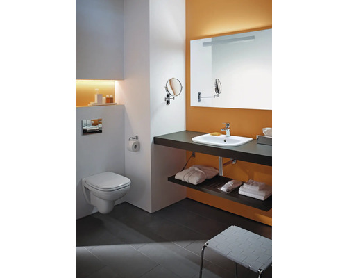 Badezimmer mit Toilette, Waschtisch, Spiegel und Ablagefläche