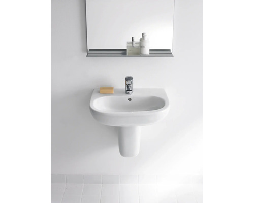 Weißes Keramikwaschbecken mit Armatur, Seife und Spiegel an der Wand