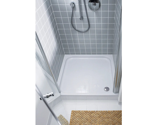 Duschkabine mit Duschwanne, Armatur und Duschkopf an gefliester Wand