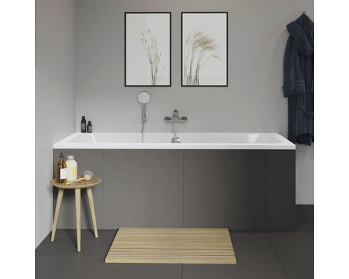 Badezimmer mit Badewanne, Armatur, Duschkopf, Badhocker, Badematte und Dekoration