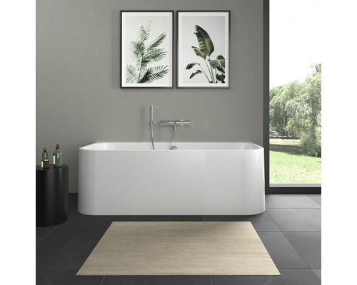 Badezimmer mit freistehender Badewanne, Teppich und Pflanzenbildern