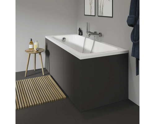 Badezimmer mit Badewanne, Armatur, Badematte aus Holz und Hocker