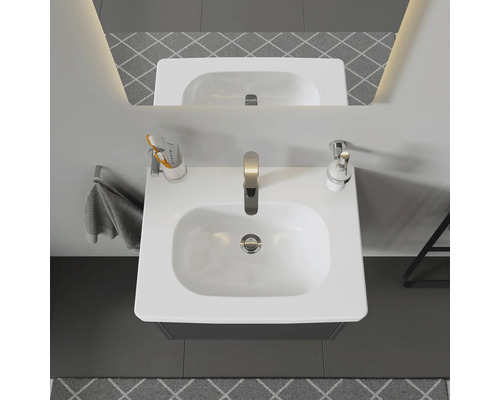 Aufnahme von oben eines Badezimmers mit Waschbecken, Armatur, Handtuch und Accessoires.