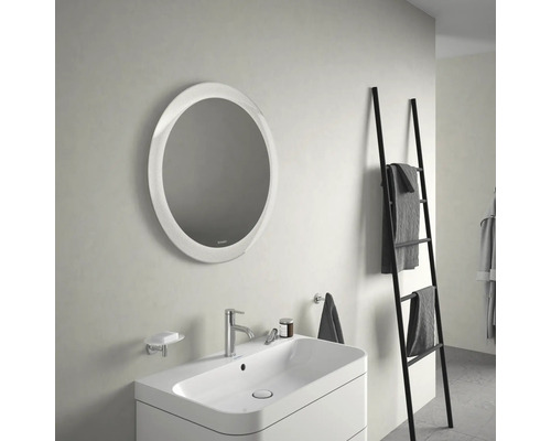 Badezimmer mit rundem Spiegel, Waschtisch und Handtuchleiter