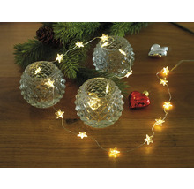 Dekoration mit Sternenlichterkette, Teelichtern und Weihnachtsbaumzweig auf Holztisch