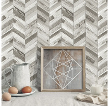 Dekoratives Interieur mit Holzwandpaneelen in Fischgrätenmuster, einem gerahmten Bild, Eiern und Kerze.