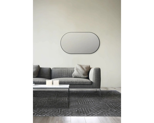 Wohnzimmer mit ovalem Wandspiegel über grauem Sofa