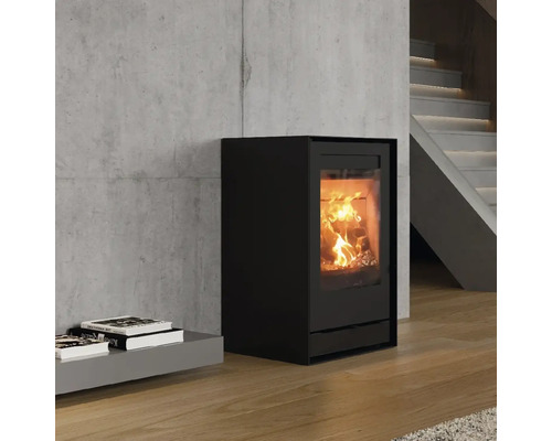 Schwarzer Kaminofen mit brennendem Holz im Innenraum in einem Wohnzimmer