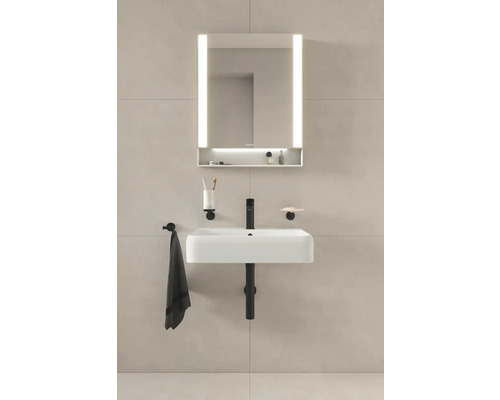 Badezimmer mit Waschbecken, Waschtisch, beleuchtetem Spiegel und Accessoires