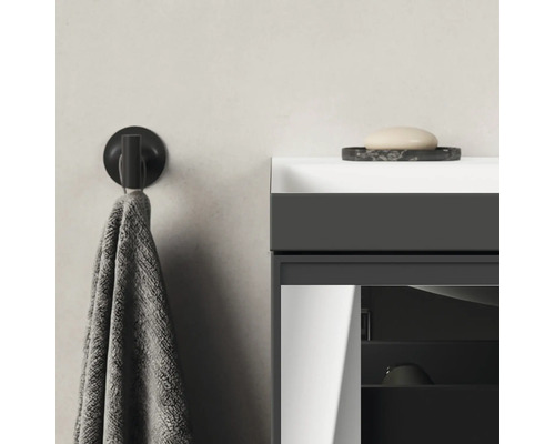 Detailaufnahme eines Badezimmers mit Handtuchhalter, Handtuch, Waschtisch und Seife