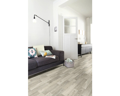 Wohnzimmer mit Sofa, Stehlampe, Kommode, Holzboden und Tür