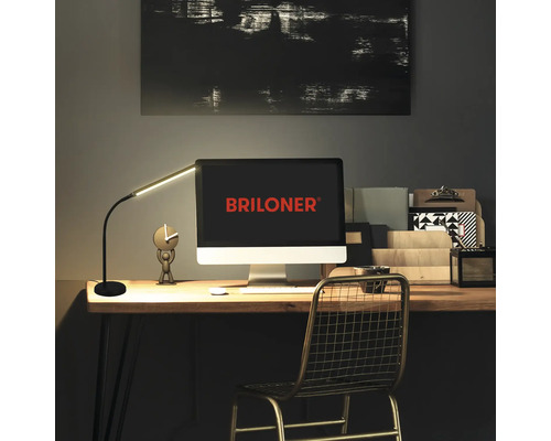 Schreibtisch mit Schreibtischlampe, Computer und Büromaterialien