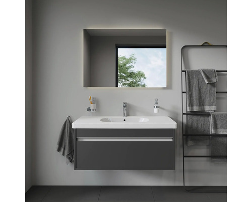 Modernes Badezimmer mit Waschtisch, beleuchtetem Spiegel und Handtuchhalter