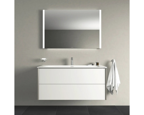 Badezimmer-Szene mit einem Waschbeckenunterschrank, einem Spiegel mit Beleuchtung, einem Seifenhalter und einem Handtuchhalter.