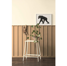 Dekoratives Interieur mit Pflanze auf einem Hocker, Holzfigur und gerahmtem Affenbild