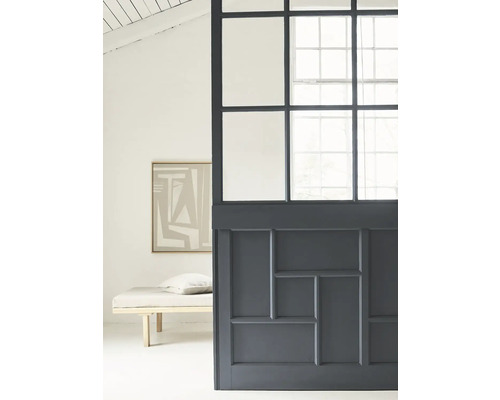 Raumansicht mit Trennwand aus Glas und Holz sowie Liege und Gemälde