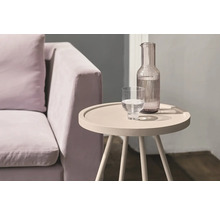 Einrichtungsszene mit Sofa, Wasserglas und Wasserkaraffe auf einem Beistelltisch.