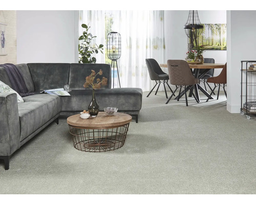 Wohnzimmer mit grauem Ecksofa, rundem Couchtisch, Esstisch und Stühlen auf Teppich