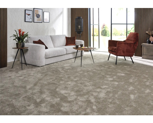 Wohnzimmer mit Teppich, Sofa, Sessel und Beistelltischen