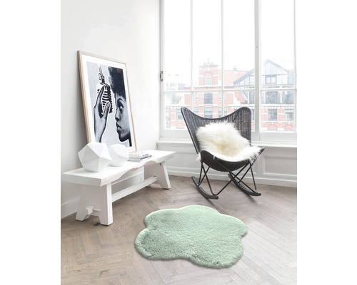 Heller Raum mit kleinem Teppich, Bank, Dekoration und Schaukelstuhl