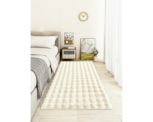 Schlafzimmer mit Bett, Nachttisch und einem rechteckigen Teppich