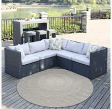 Gartenmöbel-Set mit Tisch, Hockern, Ecksofa, Kissen und rundem Teppich auf einer Terrasse am See