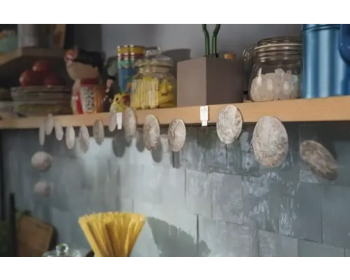 Dekorative Muschelkette an einer Küchenwand