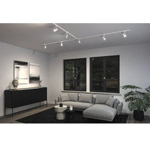 Wohnzimmer mit flexibler Schienenbeleuchtung, Sofa und Dekoration