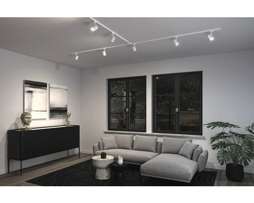 Wohnzimmer mit flexibler Schienenbeleuchtung, Sofa und Dekoration