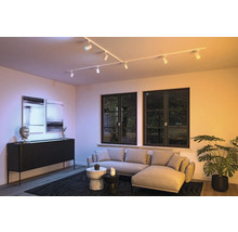 Modernes Wohnzimmer mit Schienensystem-Beleuchtung, Sofa, Kommode und Dekoration