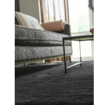 Nahaufnahme eines grauen Teppichs in einem Wohnzimmer mit Sofa und Tisch