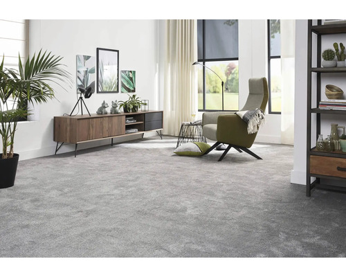 Wohnzimmer mit Teppich, Sessel, Anrichte und Dekoration