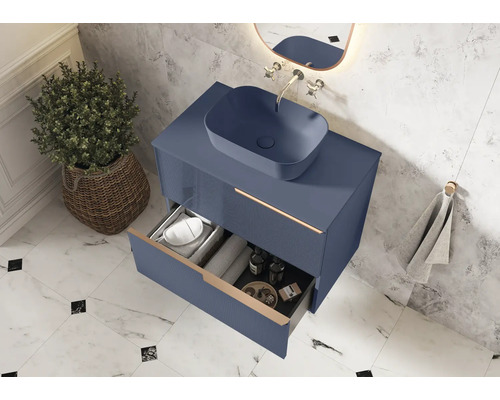 Modernes Badezimmer mit blauem Waschtischunterschrank, Aufsatzwaschbecken und offenem Schubfach zur Aufbewahrung von Badutensilien.