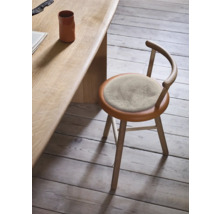 Holzstuhl mit rundem Sitzpolster an einem Holztisch