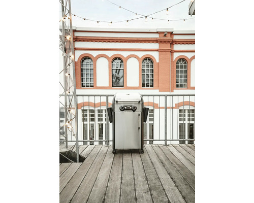 Edelstahl Gasgrill auf einer Terrasse vor einem Gebäude
