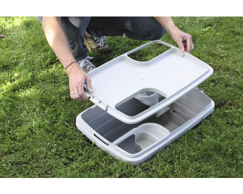 Geöffnete Aufbewahrungsbox für den Aussenbereich auf einer Rasenfläche