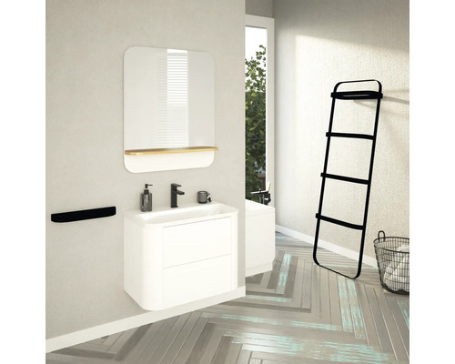 Badezimmer mit Waschtisch, Spiegel, Handtuchhalter, Leiterregal und Wäschekorb in einem hellen Raum.