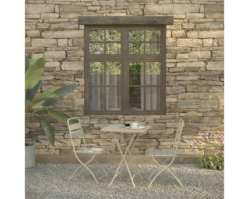 Sitzgruppe mit Tisch und zwei Stühlen vor einer Steinwand