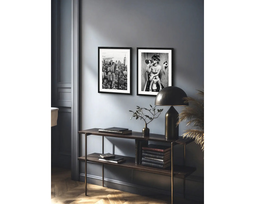 Dekoratives Wohnambiente mit Konsole, Lampe und gerahmten Bildern in Schwarzweiß