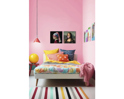 Dekoratives Schlafzimmer mit Bett, Kissen, Decke, Lampe, Teppich und Wandkunst