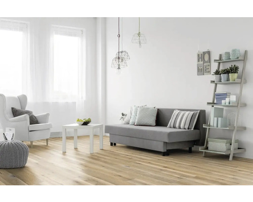 Heller Wohnraum mit Sofa, Sessel, Leiterregal und Pendelleuchten