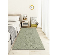 Schlafzimmer mit Bett, Nachttisch und Teppich mit Blattmuster